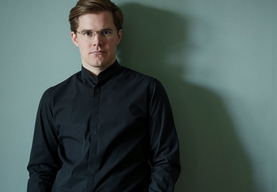 Man som lutar sig mot en färgad vägg. Fotografi.