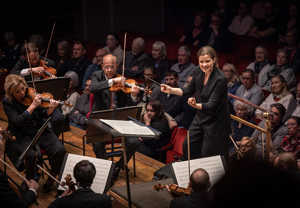 Kvinna som dirigerar. Fotografi.