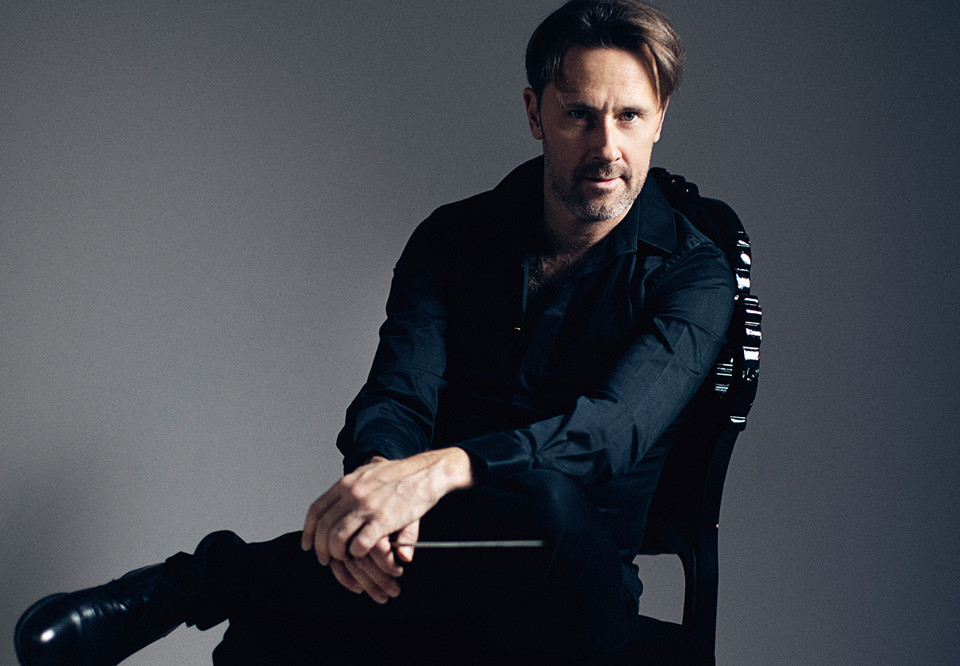 Man som sitter på en stol. Fotografi.