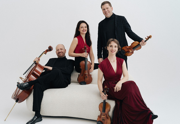 Fyra musiker som håller i sina instrument. Fotografi