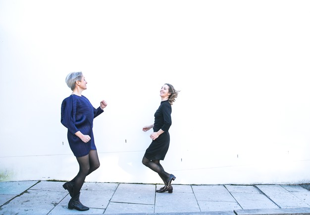 Två kvinnor som håller i en spegel. Fotografi.