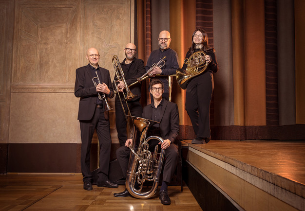 Musicians standing with their instruments. Photo.