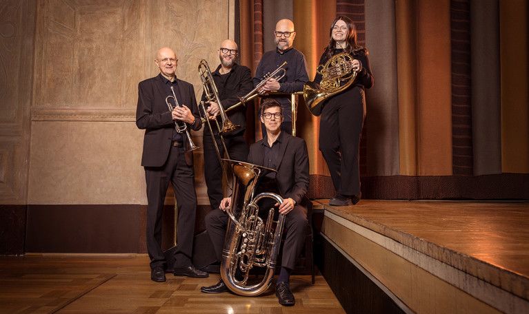 Musicians standing with their instruments. Photo.