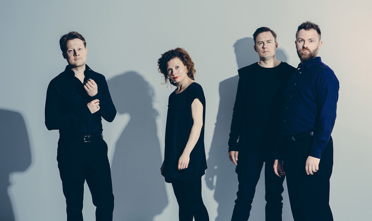 Fyra musiker på rad. Fotografi.