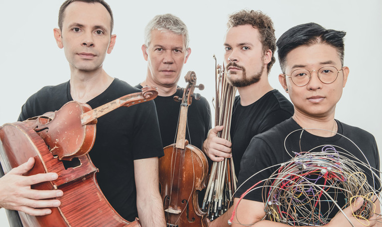 Fyra musiker med instrument. Fotografi.