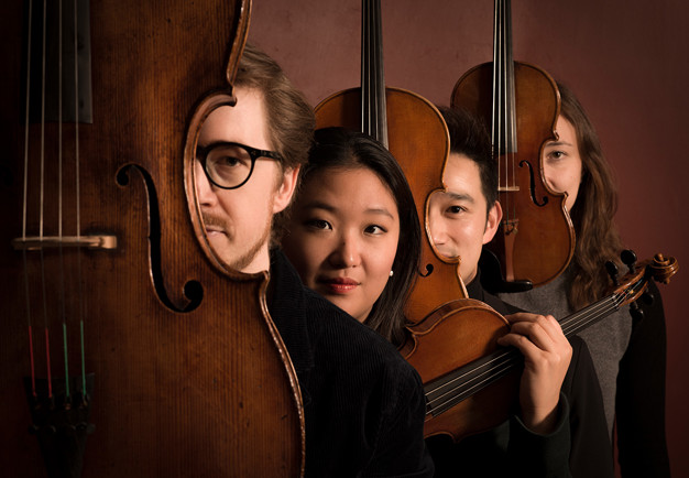 Fyra musiker på rad. Fotografi.