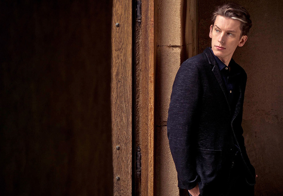 Man som lutar sig mot en vägg. Fotografi.