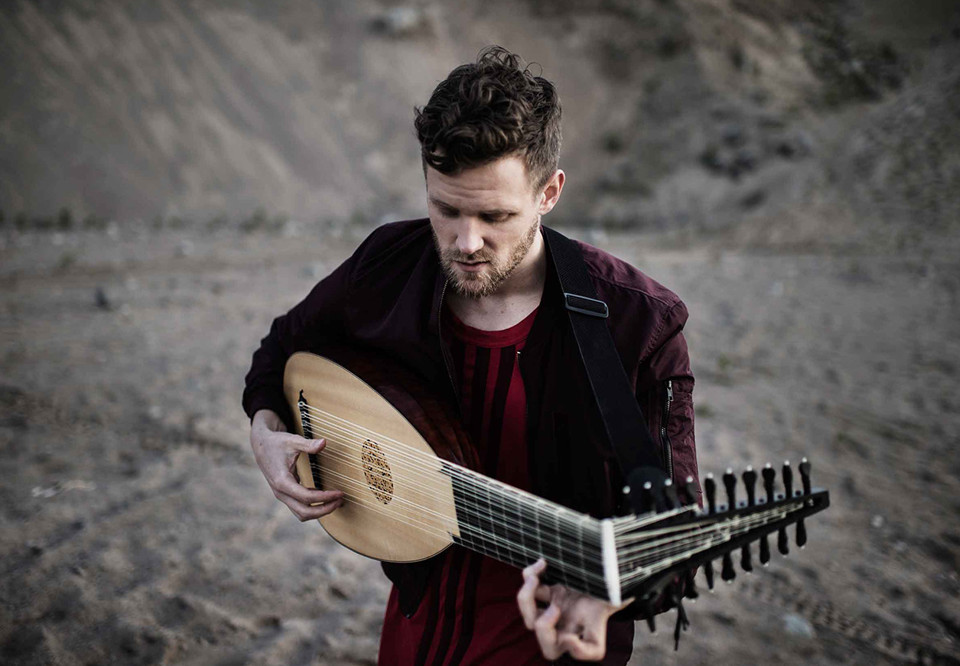 Man som spelar luta. Fotografi.