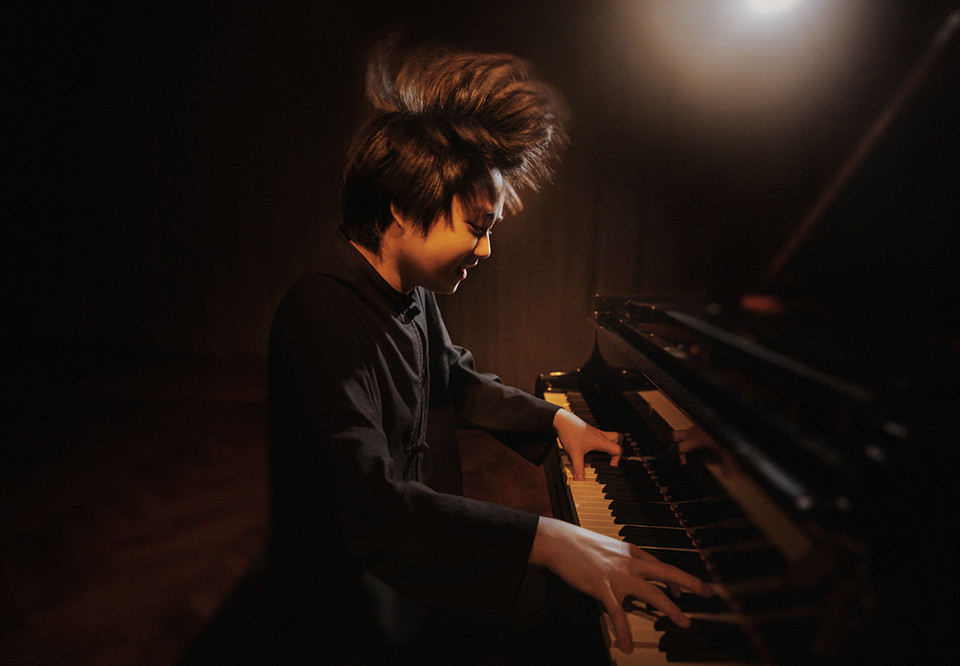 Ung kille som spelar piano. Fotografi. 