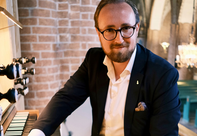 Man vid orgel. Fotografi.