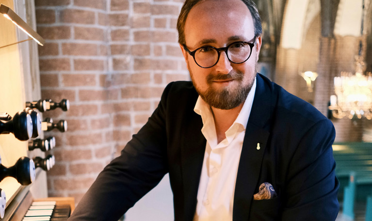 Man vid orgel. Fotografi.