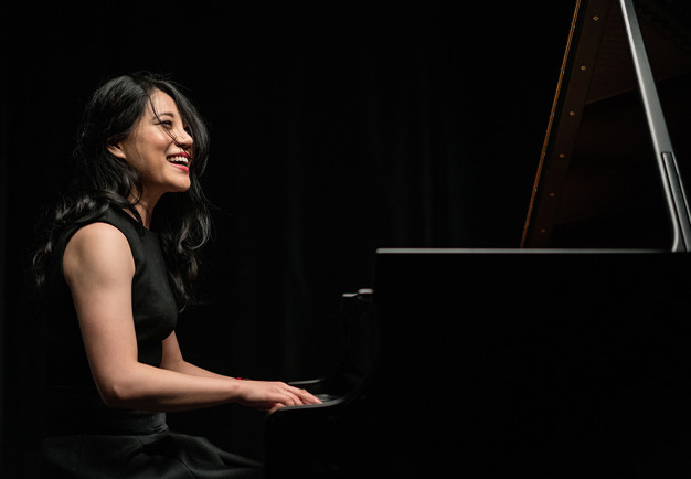 Kvinna vid piano. Fotografi.