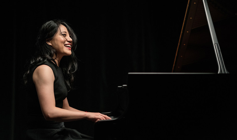 Kvinna vid piano. Fotografi.