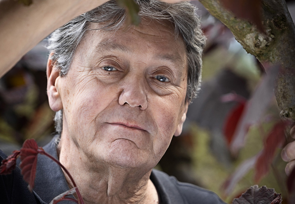 Man med skog i bakgrunden. Fotografi.